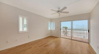 empty room featuring ceiling fan, baseboards, a wealth of natural light, and wood finished floors