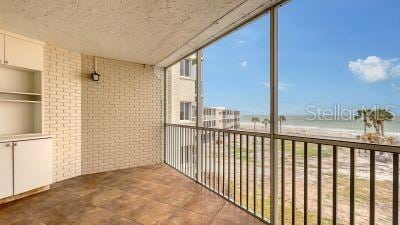 balcony with a water view and a beach view