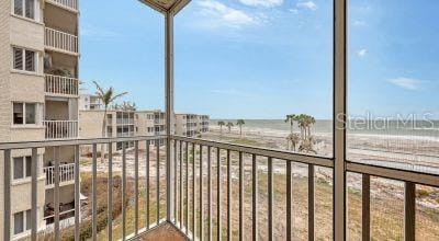 balcony with a beach view and a water view