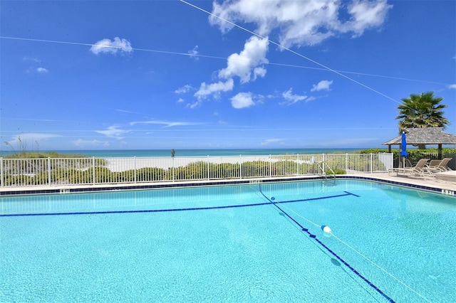 pool with a water view and fence