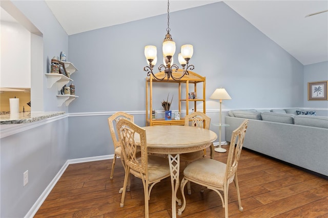 dining area with vaulted ceiling, dark hardwood / wood-style floors, and an inviting chandelier