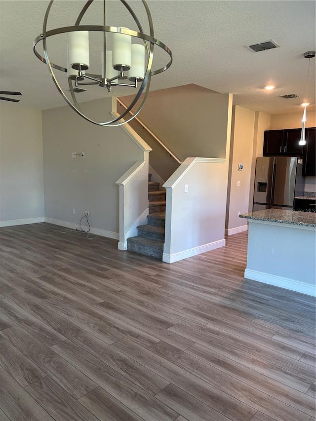 unfurnished dining area featuring dark wood-type flooring and a textured ceiling