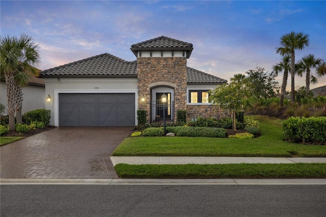 mediterranean / spanish house featuring a yard and a garage