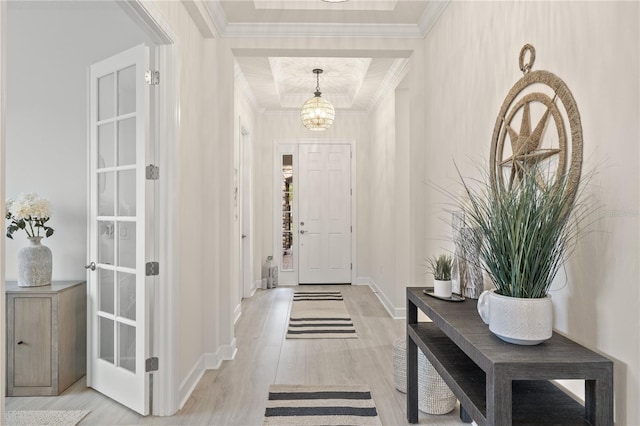 foyer with light hardwood / wood-style floors, crown molding, and a notable chandelier