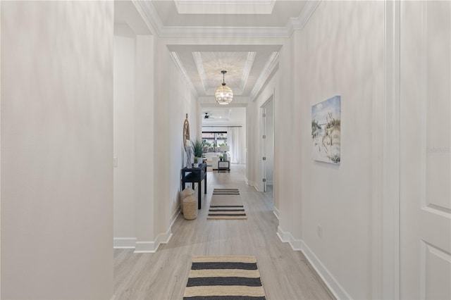 hallway featuring a chandelier, light hardwood / wood-style flooring, and crown molding