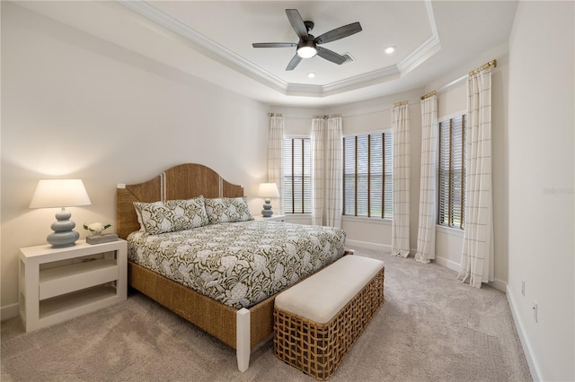 carpeted bedroom with a tray ceiling, ceiling fan, and ornamental molding