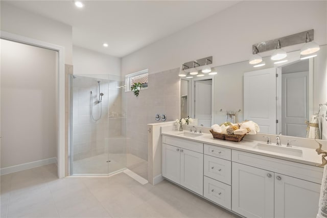 bathroom featuring tiled shower, vanity, and tile patterned flooring