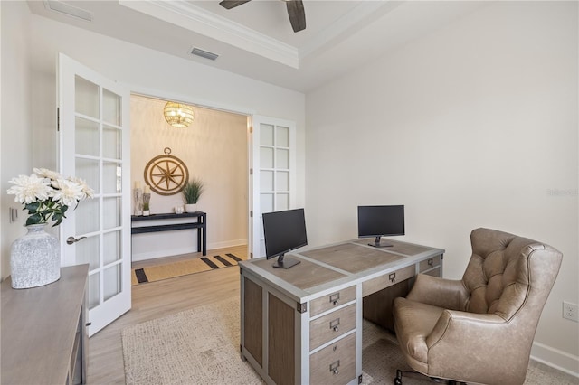 office featuring built in shelves, light hardwood / wood-style flooring, a tray ceiling, and french doors