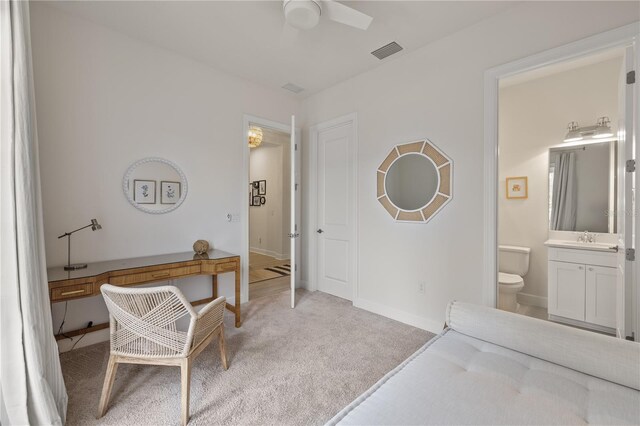 home office with ceiling fan, light colored carpet, and sink