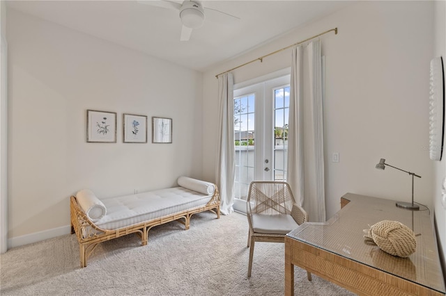 sitting room with ceiling fan, light colored carpet, and french doors