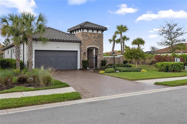 mediterranean / spanish home featuring a front lawn and a garage