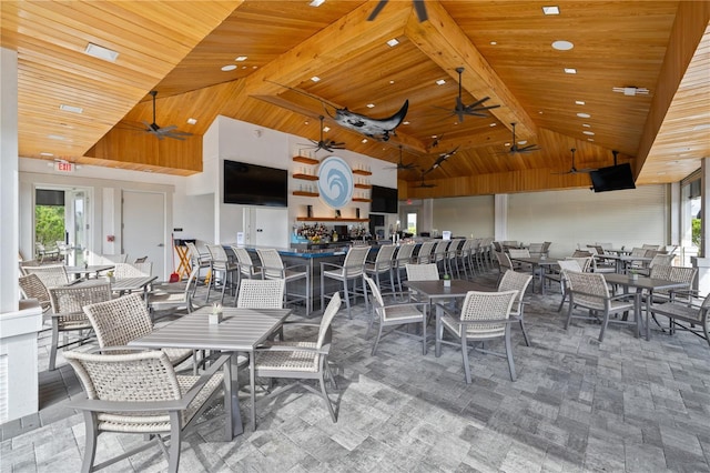 dining space with ceiling fan, wood ceiling, and high vaulted ceiling