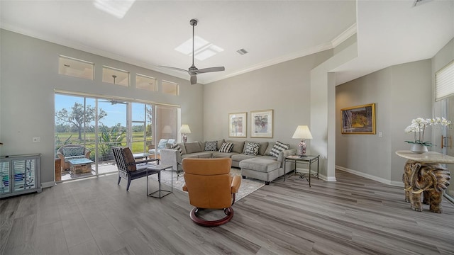 living room with light hardwood / wood-style flooring, ceiling fan, and crown molding