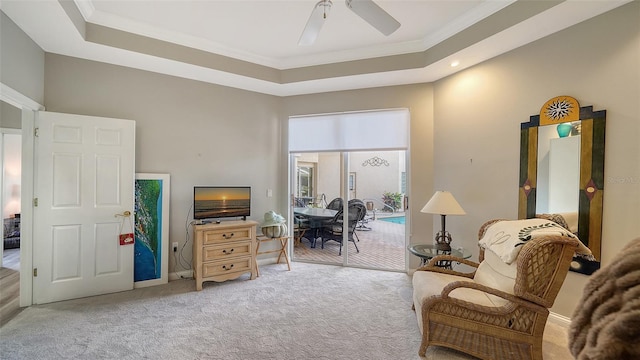 sitting room featuring carpet floors, a raised ceiling, ceiling fan, and crown molding