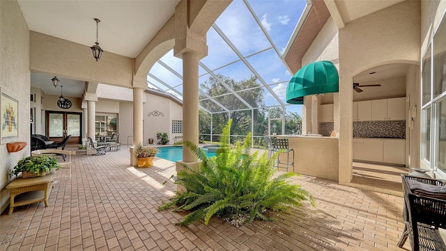 view of swimming pool with glass enclosure, a patio area, and french doors