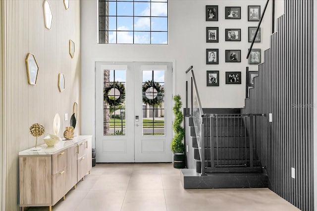 entrance foyer with french doors, light tile patterned floors, and a high ceiling