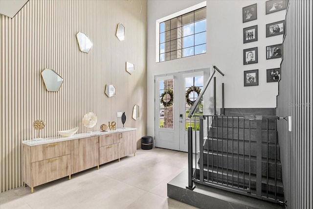 entryway featuring light tile patterned flooring and a towering ceiling