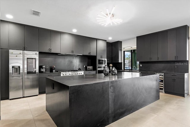 kitchen featuring decorative backsplash, a center island, stainless steel appliances, and beverage cooler