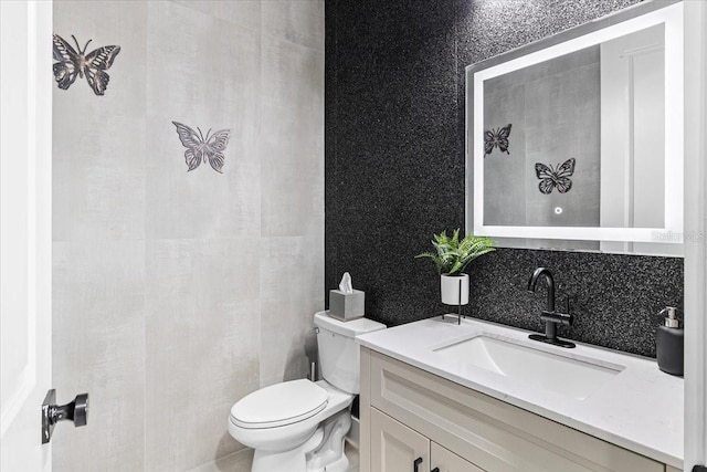 bathroom with vanity, tasteful backsplash, and toilet