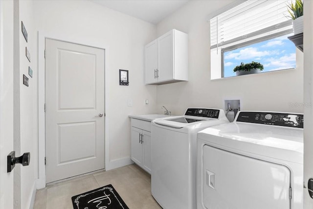 clothes washing area featuring sink, light tile patterned flooring, cabinets, and independent washer and dryer