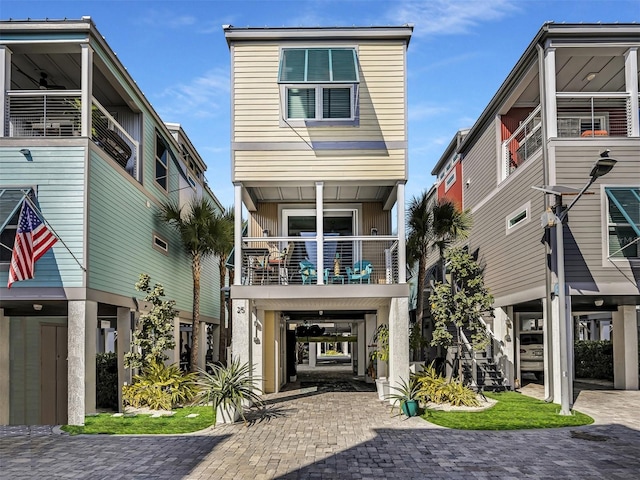 view of front of property featuring a balcony and a carport