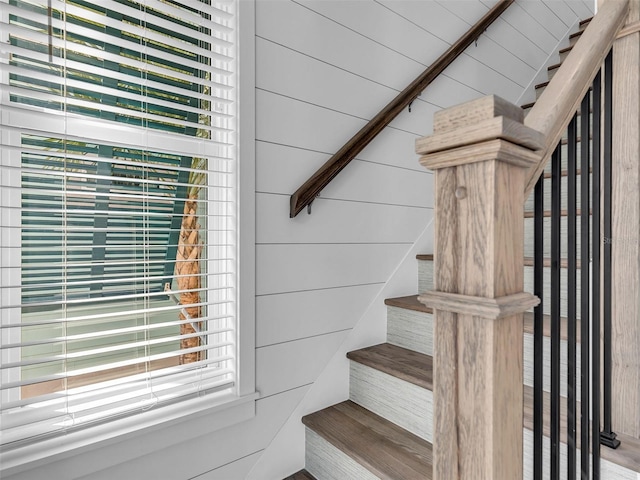 staircase with a wealth of natural light and wooden walls