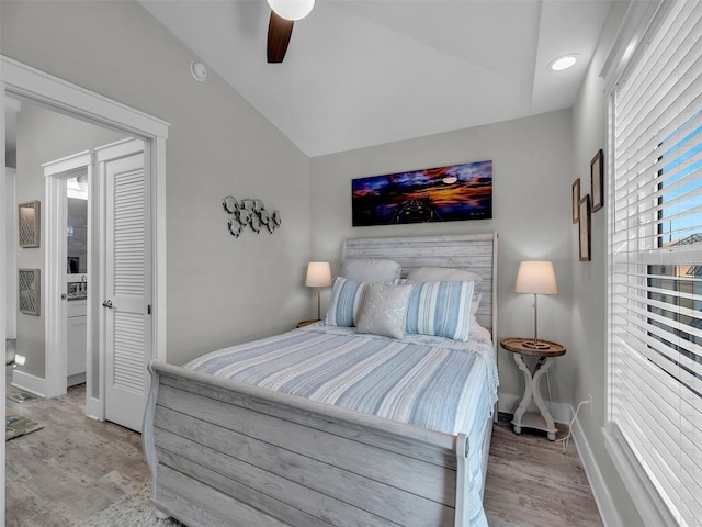 bedroom with ceiling fan, light hardwood / wood-style floors, and vaulted ceiling