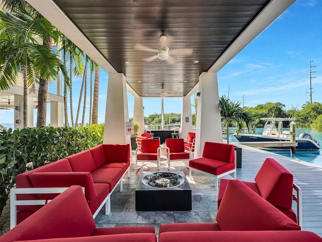 view of patio featuring ceiling fan and an outdoor living space with a fire pit