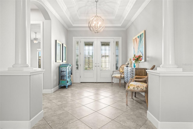 foyer with french doors, a raised ceiling, a notable chandelier, light tile patterned floors, and ornamental molding