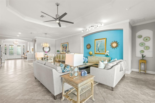 tiled living room with french doors, rail lighting, ceiling fan with notable chandelier, a raised ceiling, and crown molding