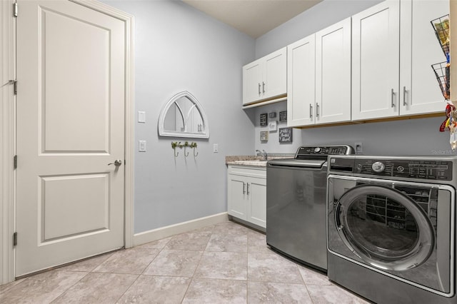 clothes washing area featuring cabinets, sink, light tile patterned flooring, and washer and dryer