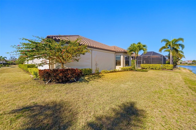 view of yard featuring a lanai and a water view