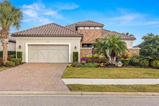 mediterranean / spanish-style house featuring a front lawn and a garage