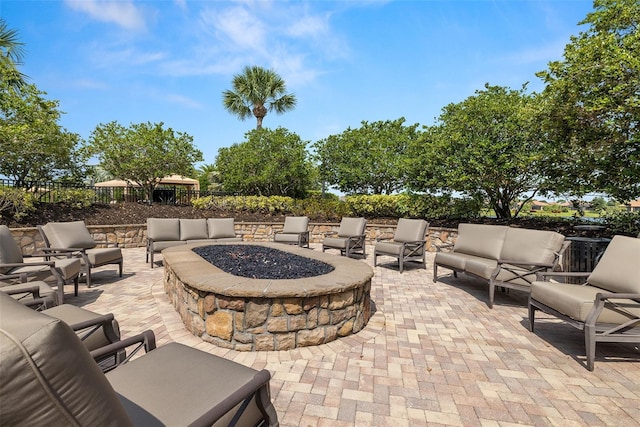 view of patio with an outdoor living space with a fire pit