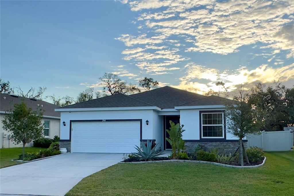 ranch-style house featuring a lawn and a garage