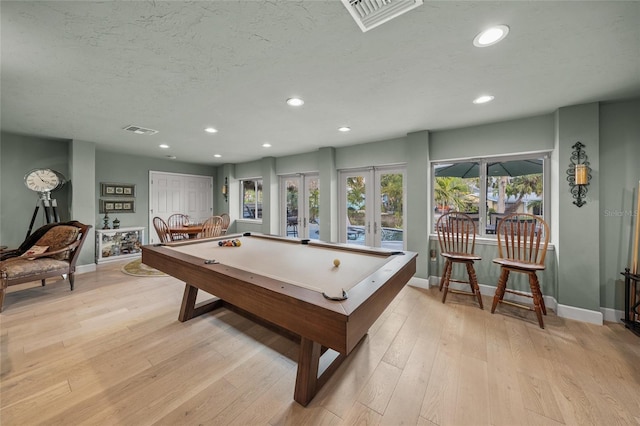 playroom featuring french doors, light hardwood / wood-style floors, a textured ceiling, and pool table