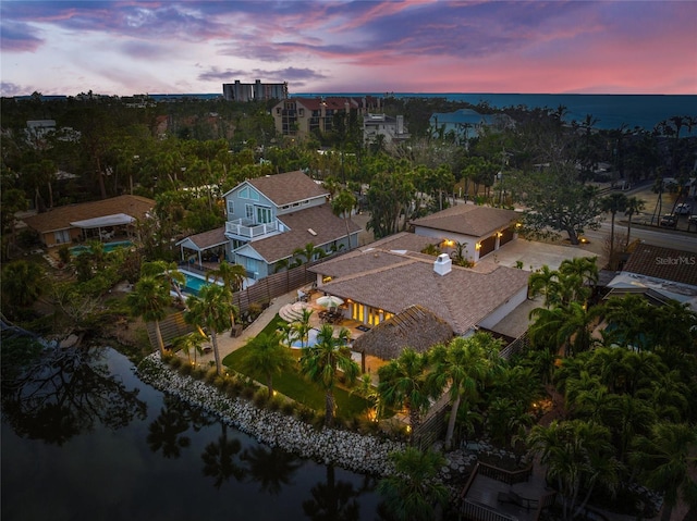 aerial view at dusk featuring a water view