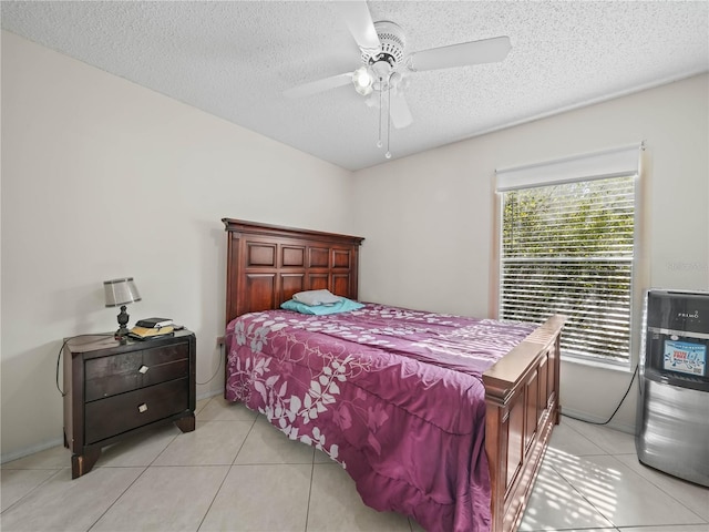 bedroom featuring ceiling fan, light tile patterned floors, and a textured ceiling