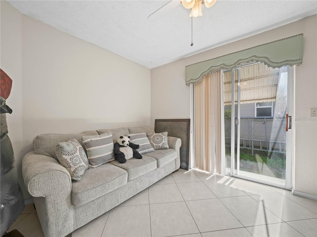 living room with a wealth of natural light, light tile patterned flooring, a textured ceiling, and ceiling fan