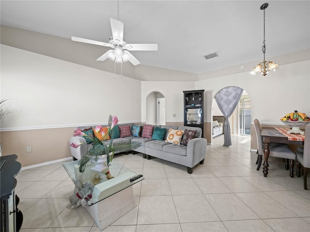 living room featuring ceiling fan with notable chandelier and light tile patterned floors