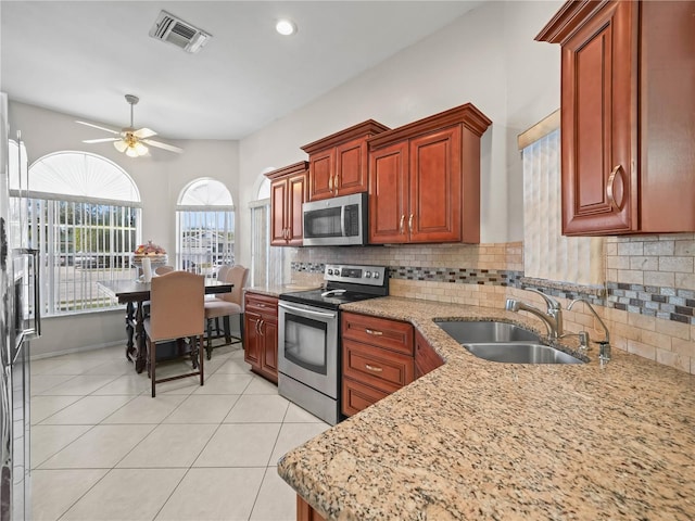 kitchen with ceiling fan, sink, tasteful backsplash, light tile patterned flooring, and appliances with stainless steel finishes