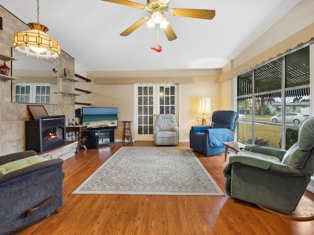 living room with ceiling fan, hardwood / wood-style floors, and a fireplace