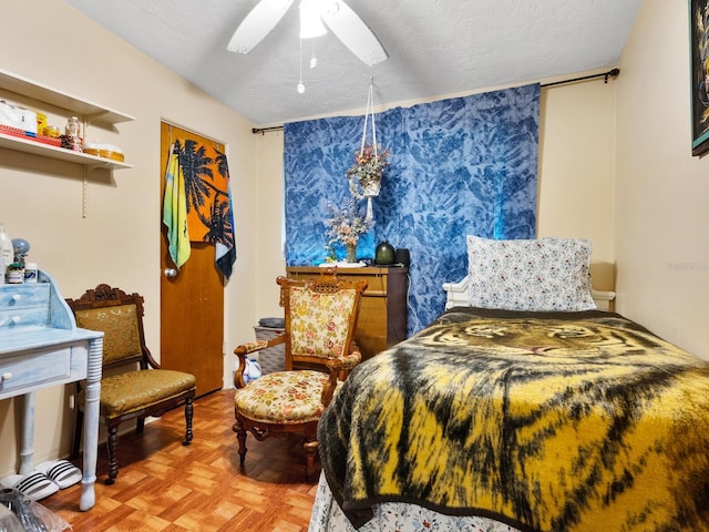 bedroom with parquet floors, ceiling fan, a closet, and a textured ceiling