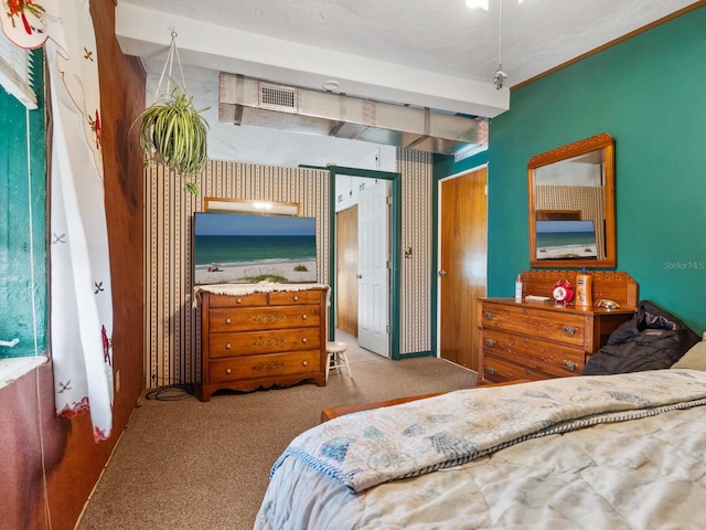 bedroom with light colored carpet and a textured ceiling