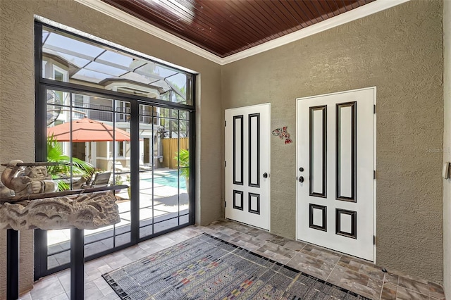 entryway with a healthy amount of sunlight, wooden ceiling, and ornamental molding