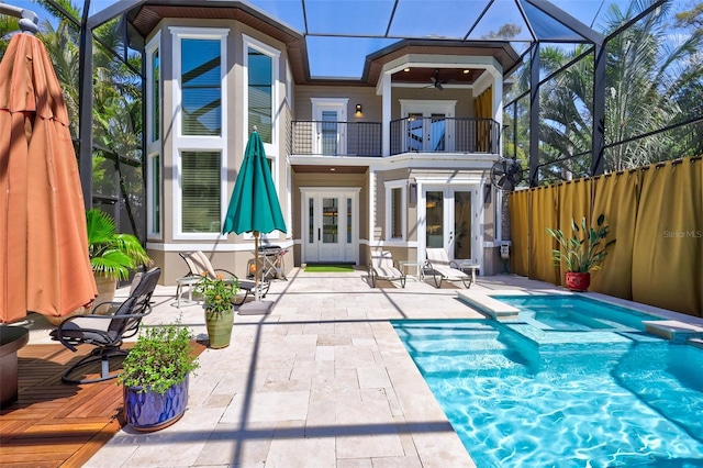 back of property featuring french doors, ceiling fan, a lanai, a balcony, and a patio