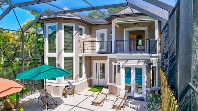 rear view of house featuring french doors, a balcony, ceiling fan, and a lanai