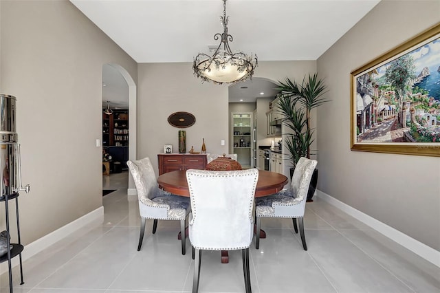 dining space featuring light tile patterned flooring and a chandelier