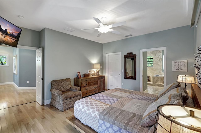 bedroom with ceiling fan, ensuite bath, and light hardwood / wood-style flooring