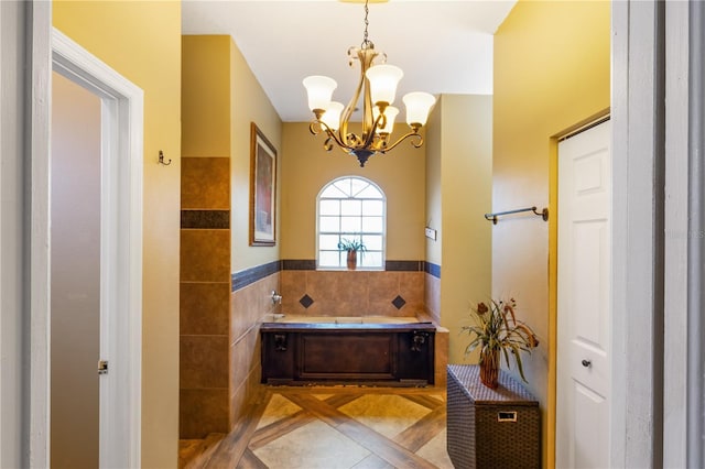 bathroom with tile patterned floors, tile walls, a tub to relax in, and an inviting chandelier